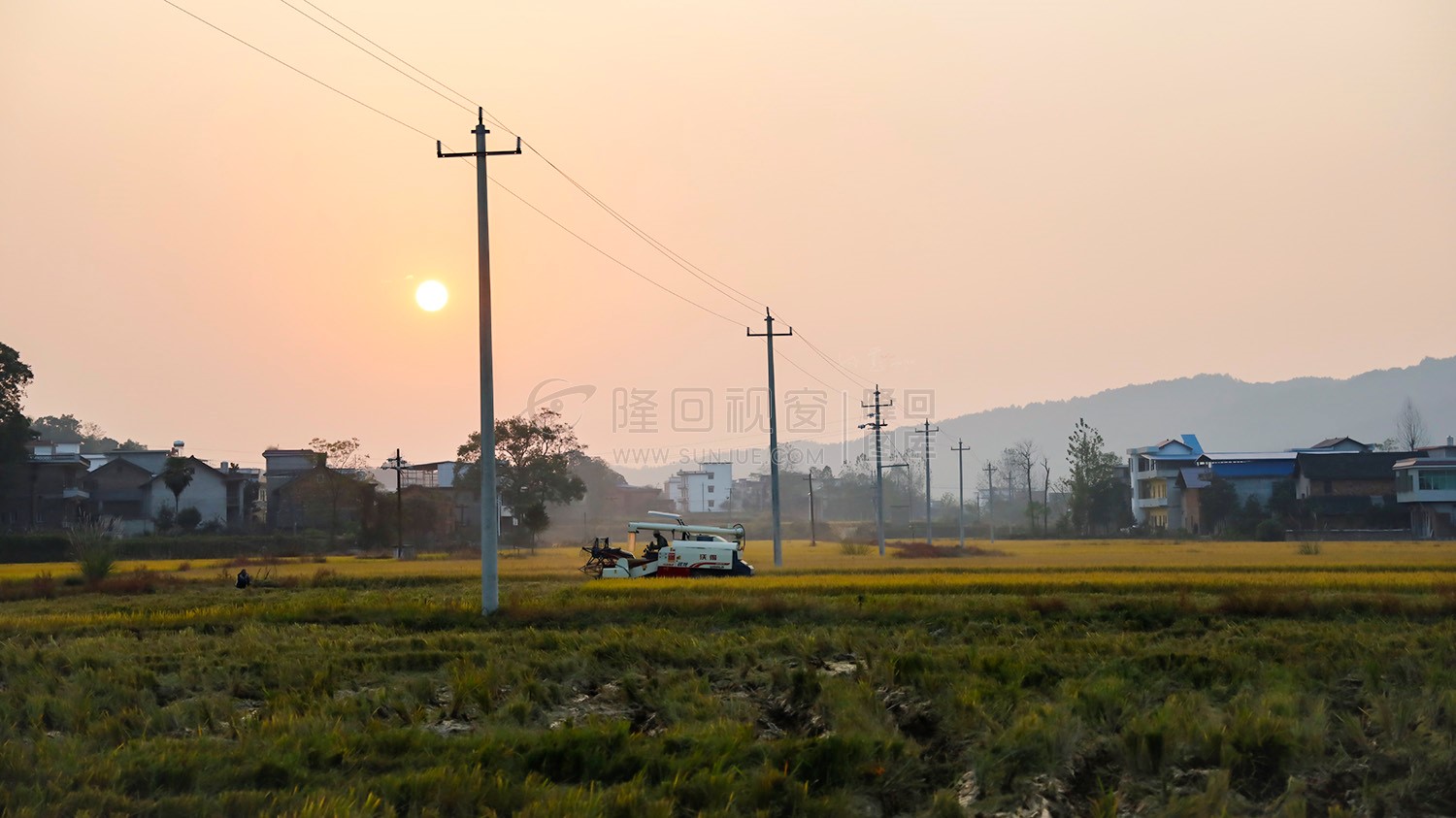 夕阳西下，收割机还在忙碌着，秋收季