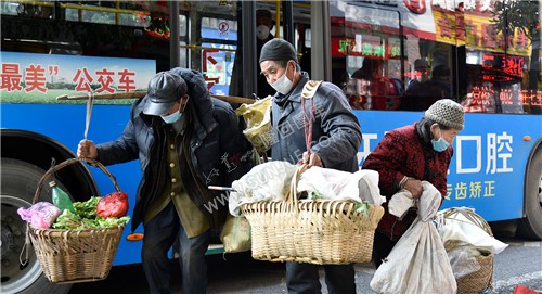 菜农清早挑着自己种的蔬菜坐公交车到城里售卖