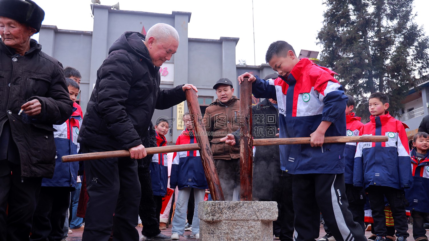 爷爷带学生舂糍粑