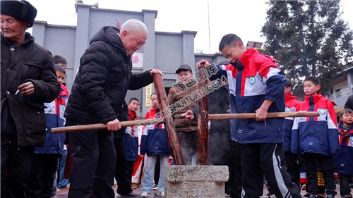 爷爷带学生舂糍粑